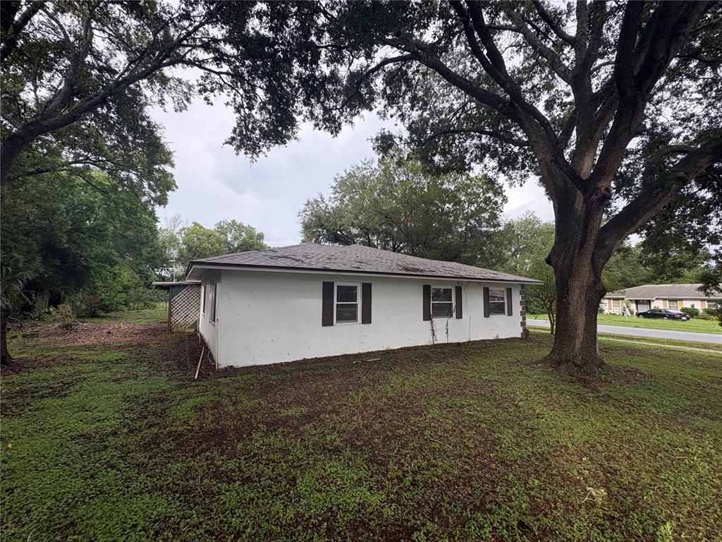 A white, single-story house with a dark roof sits on a grassy lot with trees — 9202 N ABBOT DRIVE, CITRUS SPRINGS, FL