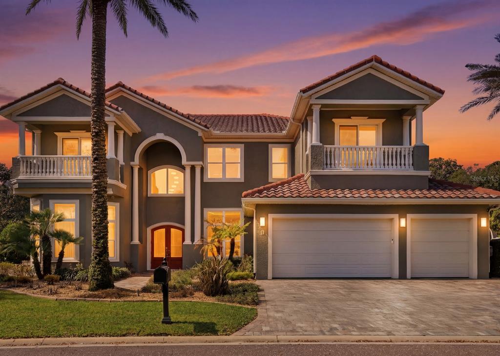 A two-story house with a green stucco exterior, orange front door, and tiled roof — 11 OCEAN OAKS LANE, PALM COAST, FL