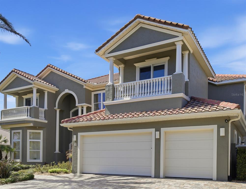 A two-story house exterior with a tiled roof, two garage doors, and two upper balconies — 11 OCEAN OAKS LANE, PALM COAST, FL