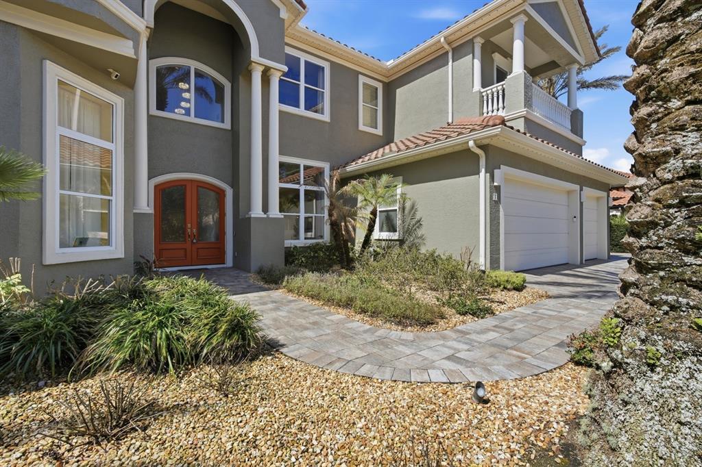 A two-story house with a gray exterior, orange double front doors, and a paved walkway — 11 OCEAN OAKS LANE, PALM COAST, FL