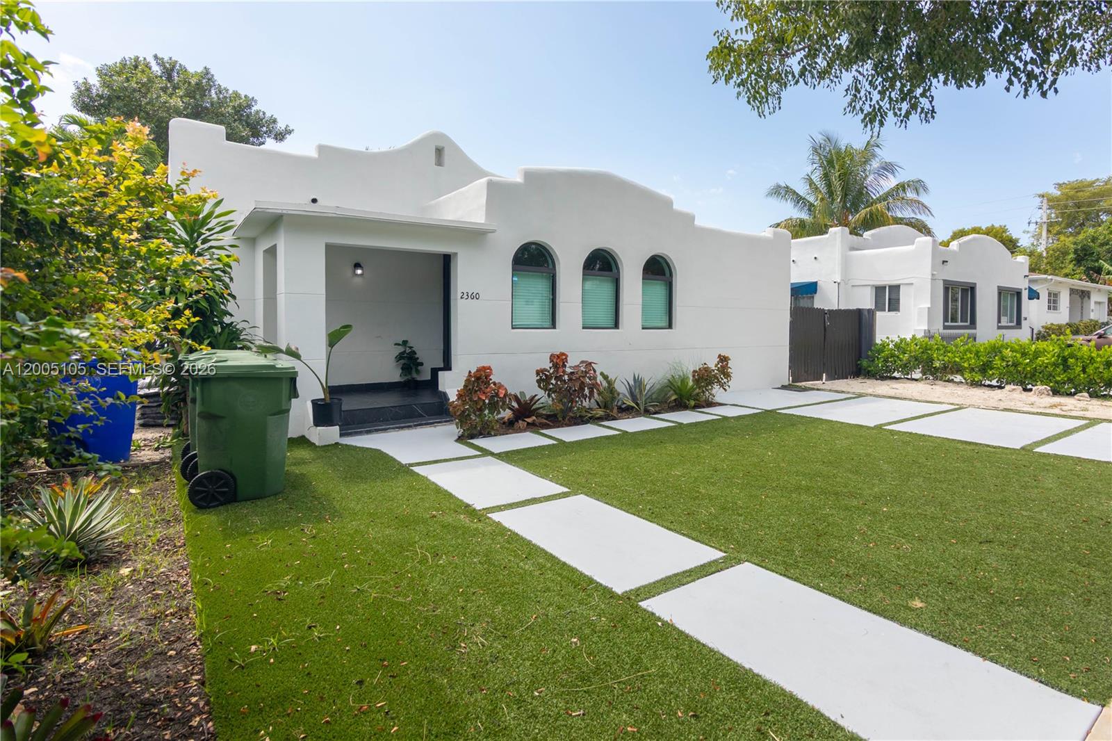 A white stucco house with arched windows and a paved walkway across a green lawn — 2360 SW 12th St, Miami FL 33135, MIAMI, FL