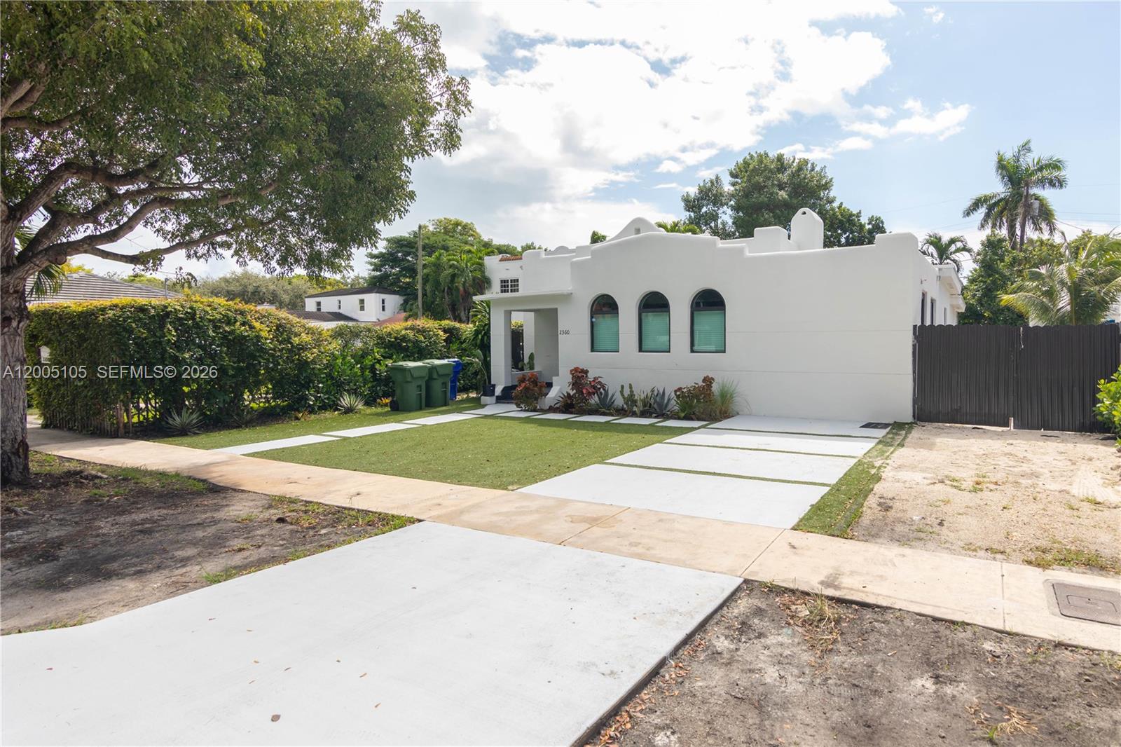 A white, single-story house with arched windows features a front lawn and concrete driveway — 2360 SW 12th St, Miami FL 33135, MIAMI, FL