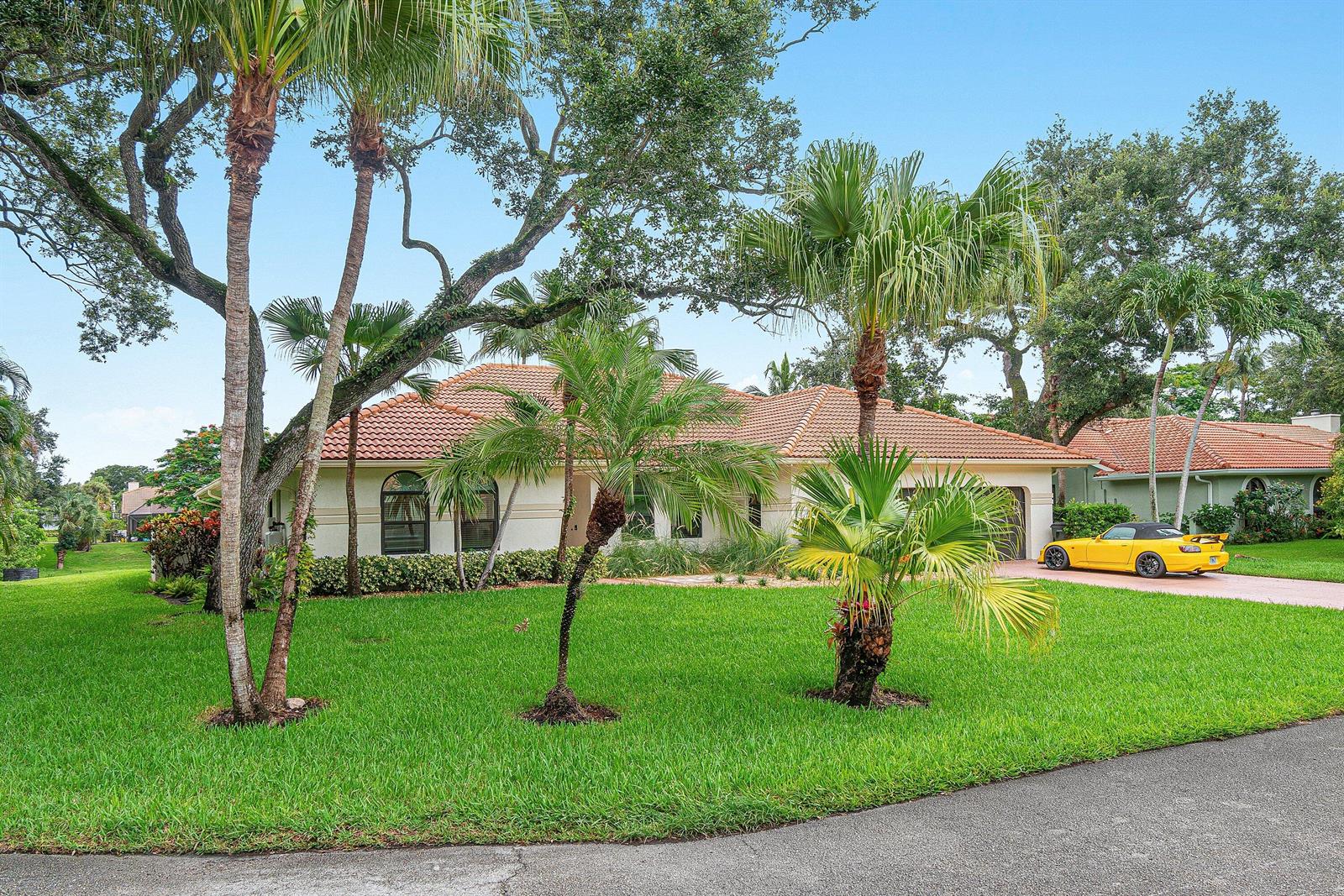 A swimming pool with a screened enclosure overlooks a lake and neighboring houses — 3615 SW 24th Lane, Delray Beach FL 33445, DELRAY BEACH, FL