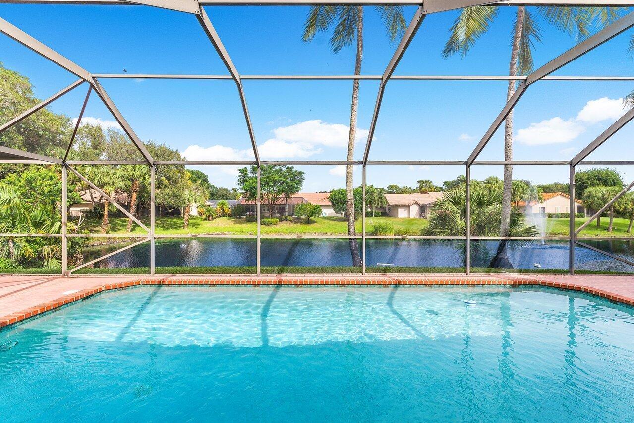 A spacious living room features light tile floors, a large sectional sofa, and sliding glass doors — 3615 SW 24th Lane, Delray Beach FL 33445, DELRAY BEACH, FL