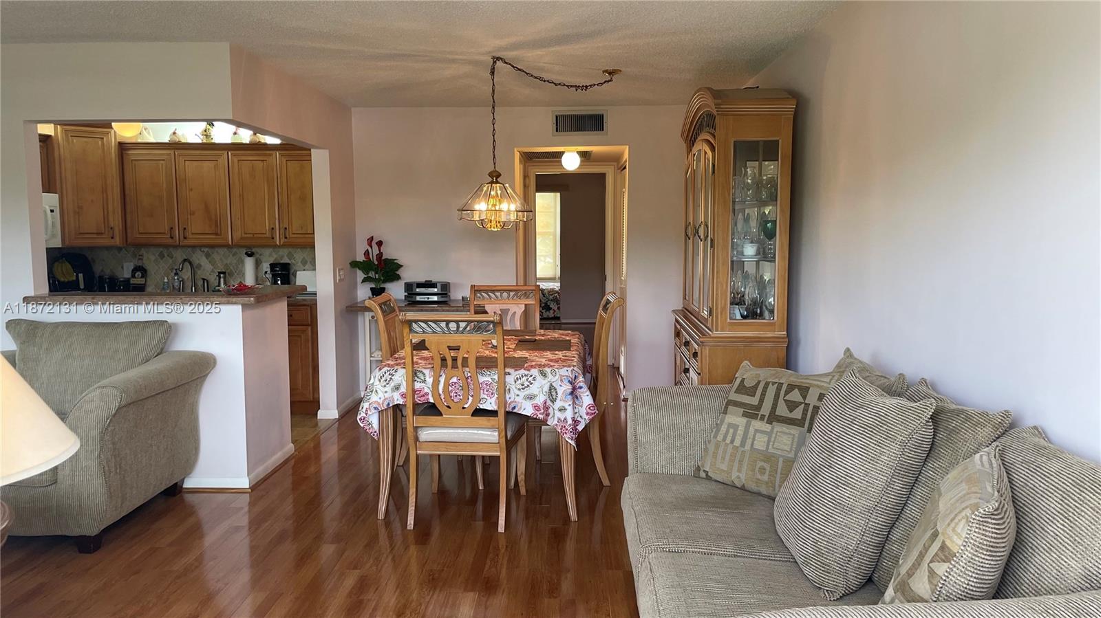 A dining area with a wooden table and hutch sits between a kitchen and living room — 3033 Berkshire B # 3033, Deerfield Beach FL 33442, DEERFIELD BEACH, FL