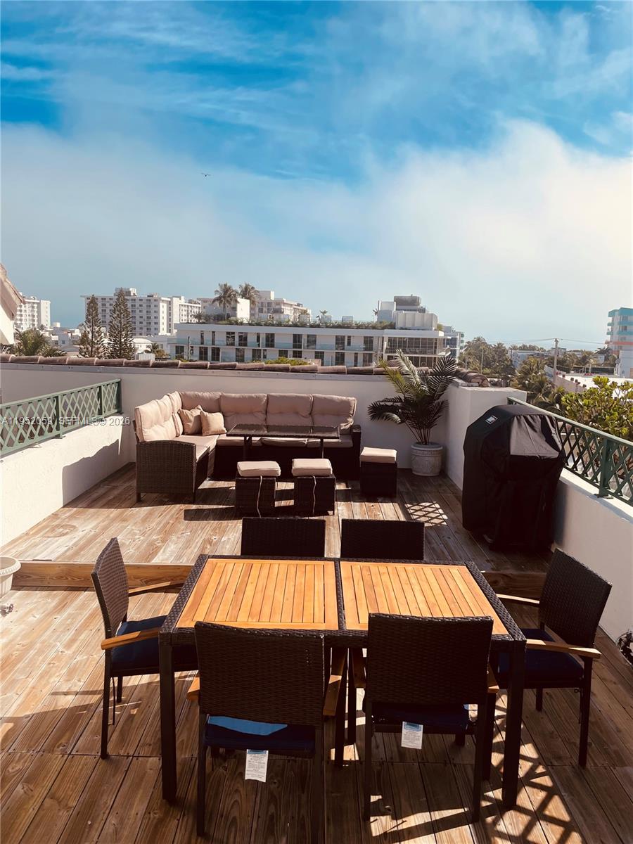 A rooftop deck features a wooden dining set, a sectional sofa, and a covered grill — 300 Euclid Ave # 209, Miami Beach FL 33139, MIAMI BEACH, FL
