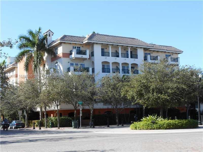 A multi-story residential building with balconies and a tiled roof stands behind trees — 300 Euclid Ave # 209, Miami Beach FL 33139, MIAMI BEACH, FL