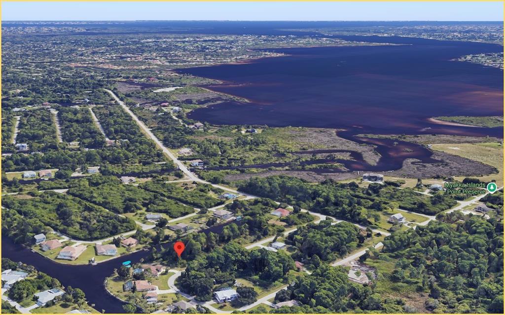 Aerial view of a residential neighborhood bordering a large body of water and a preserve — 1144 ANAHEIM STREET, PORT CHARLOTTE, FL