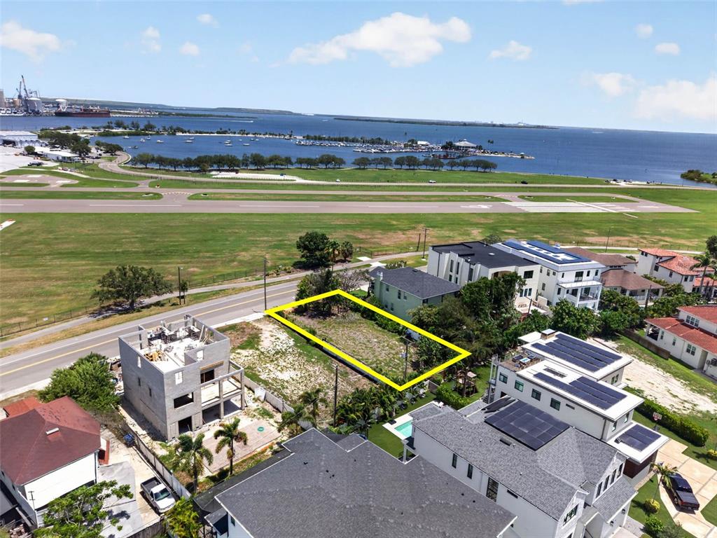 An aerial view shows a vacant rectangular lot outlined in yellow between two residential buildings — 830 S DAVIS BOULEVARD, TAMPA, FL