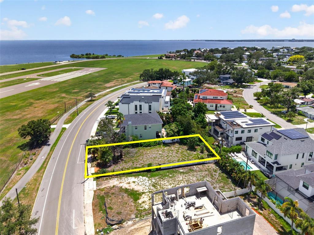 An aerial view shows a vacant rectangular lot outlined in yellow next to a road — 830 S DAVIS BOULEVARD, TAMPA, FL