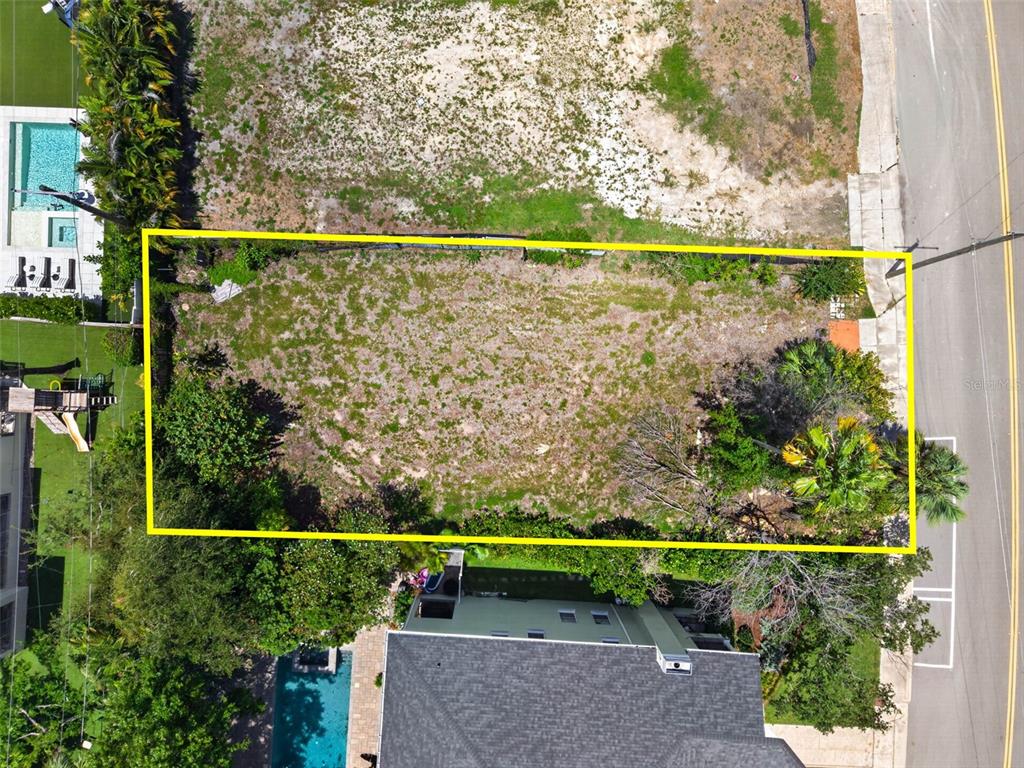 An aerial view shows a rectangular vacant lot outlined in yellow next to a road — 830 S DAVIS BOULEVARD, TAMPA, FL