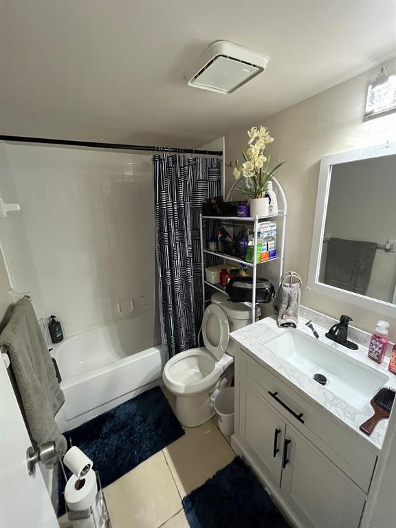 A bathroom features a white vanity, a toilet, and a shower-tub combo with a patterned curtain — CORAL SPRINGS, FL