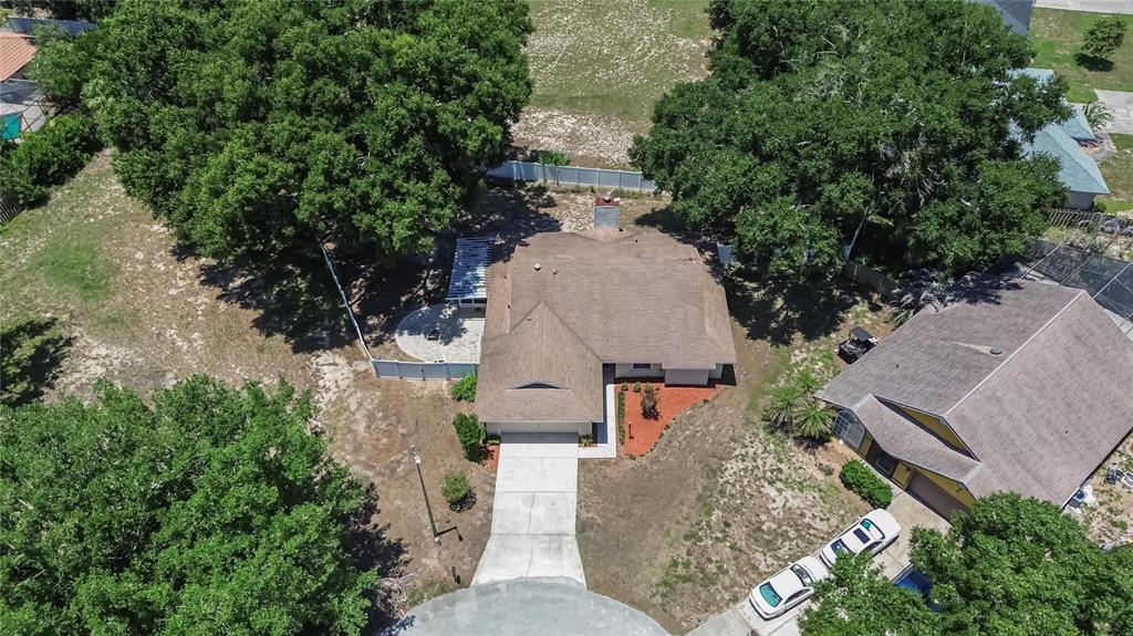 An aerial view shows a single-story house with a brown roof, driveway, and surrounding trees — 328 VAIL DRIVE, WINTER HAVEN, FL