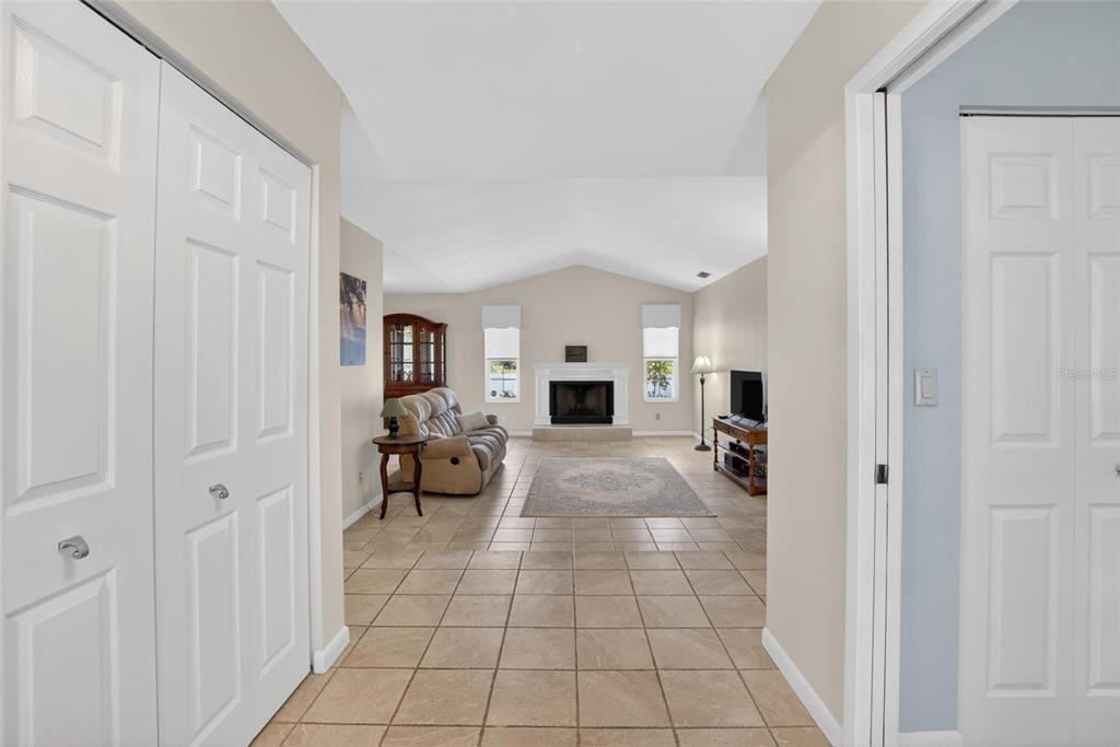 A view from a hallway into a living room with tile floors and a fireplace — 328 VAIL DRIVE, WINTER HAVEN, FL
