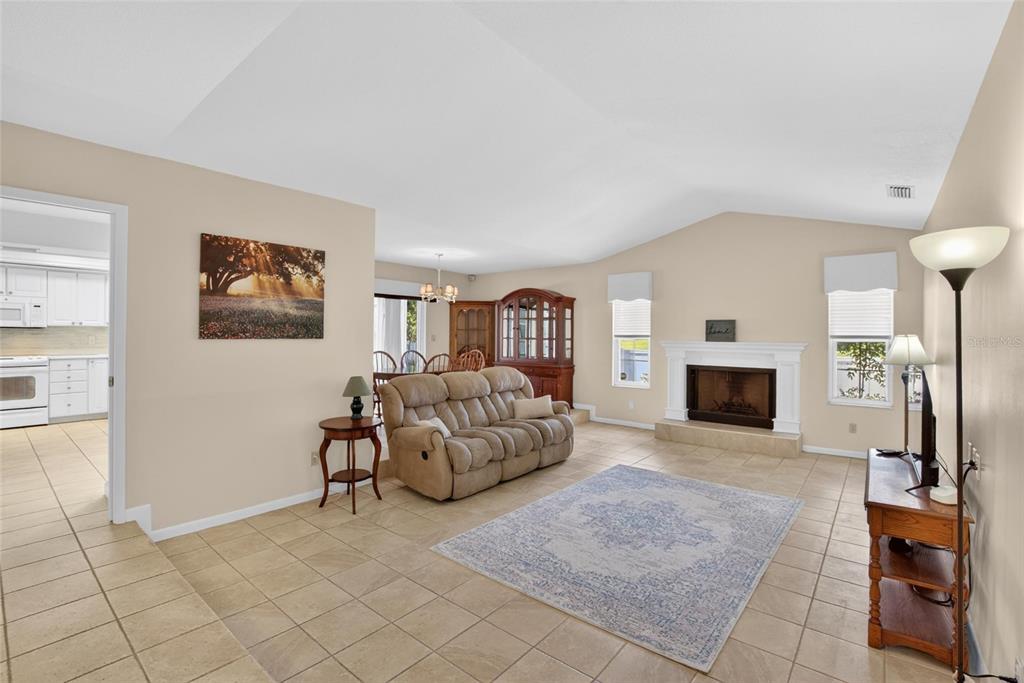 A living room with tile flooring, a fireplace, and a beige sofa — 328 VAIL DRIVE, WINTER HAVEN, FL