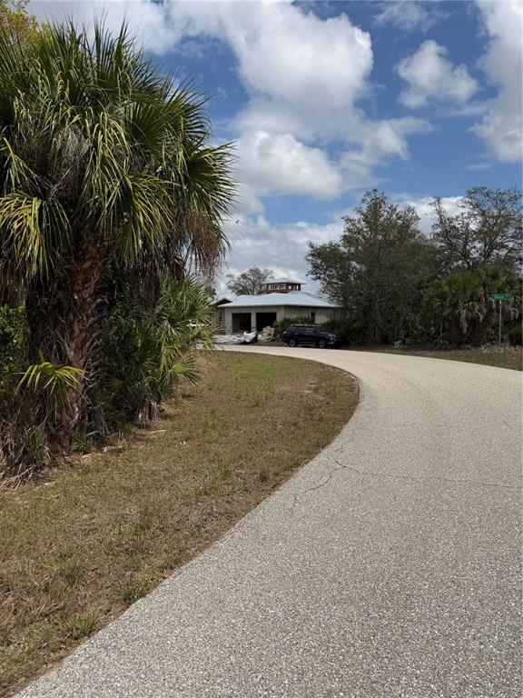 A paved road leads toward a house under construction with a prominent cupola roof — 12515 SUNNILAND AVENUE, PORT CHARLOTTE, FL