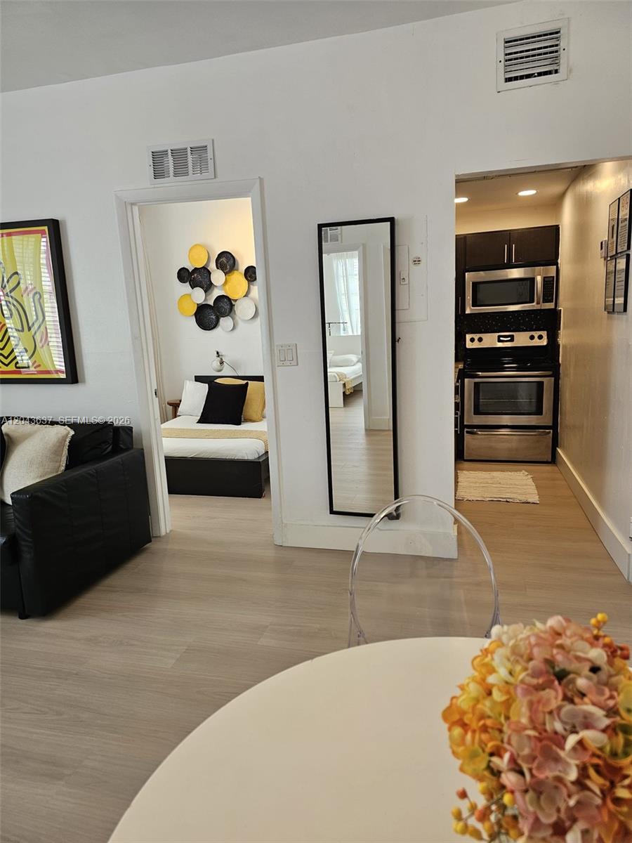 A view from a dining area looking into a bedroom and a galley kitchen — 750 Collins Ave # 306, Miami Beach FL 33139, MIAMI BEACH, FL