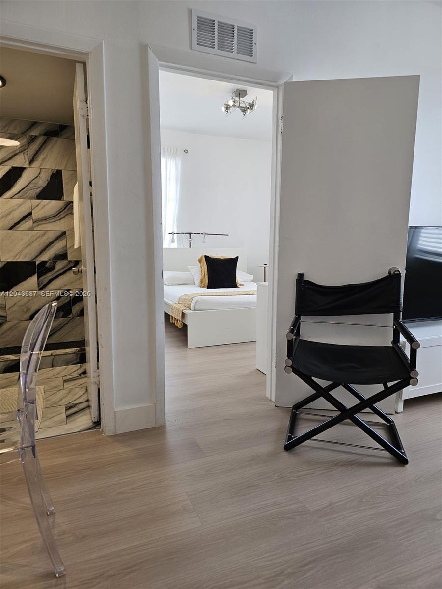 A view through a doorway shows a bedroom with a bed, white walls, and flooring — 750 Collins Ave # 306, Miami Beach FL 33139, MIAMI BEACH, FL