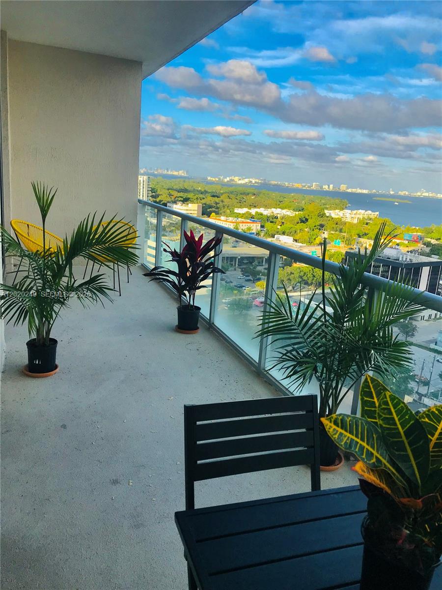 An empty living room features white tile floors, floor-to-ceiling windows, and a city view — 3470 E Coast Ave # H1712, Miami FL 33137, MIAMI, FL