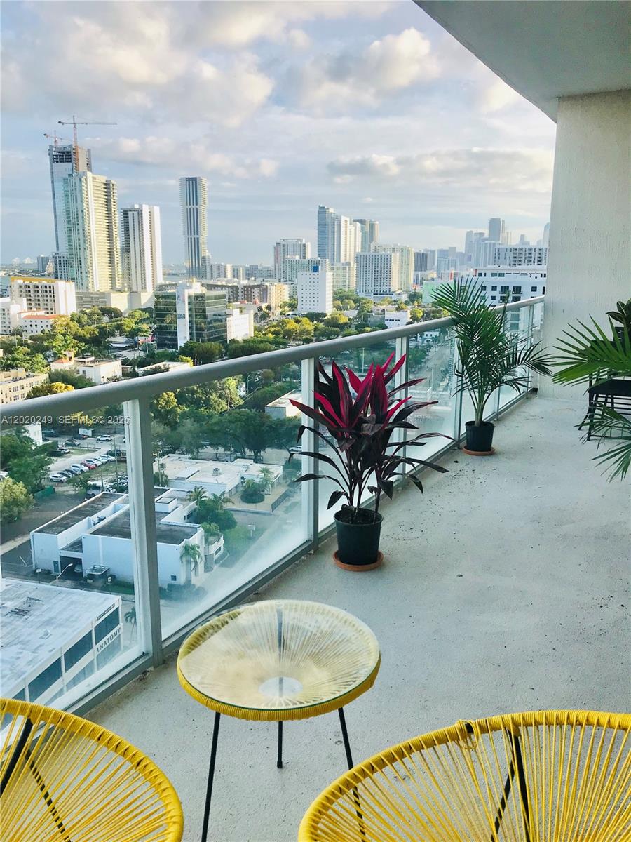 A living and dining area features white tile floors, a teal sofa, and floor-to-ceiling windows — 3470 E Coast Ave # H1712, Miami FL 33137, MIAMI, FL