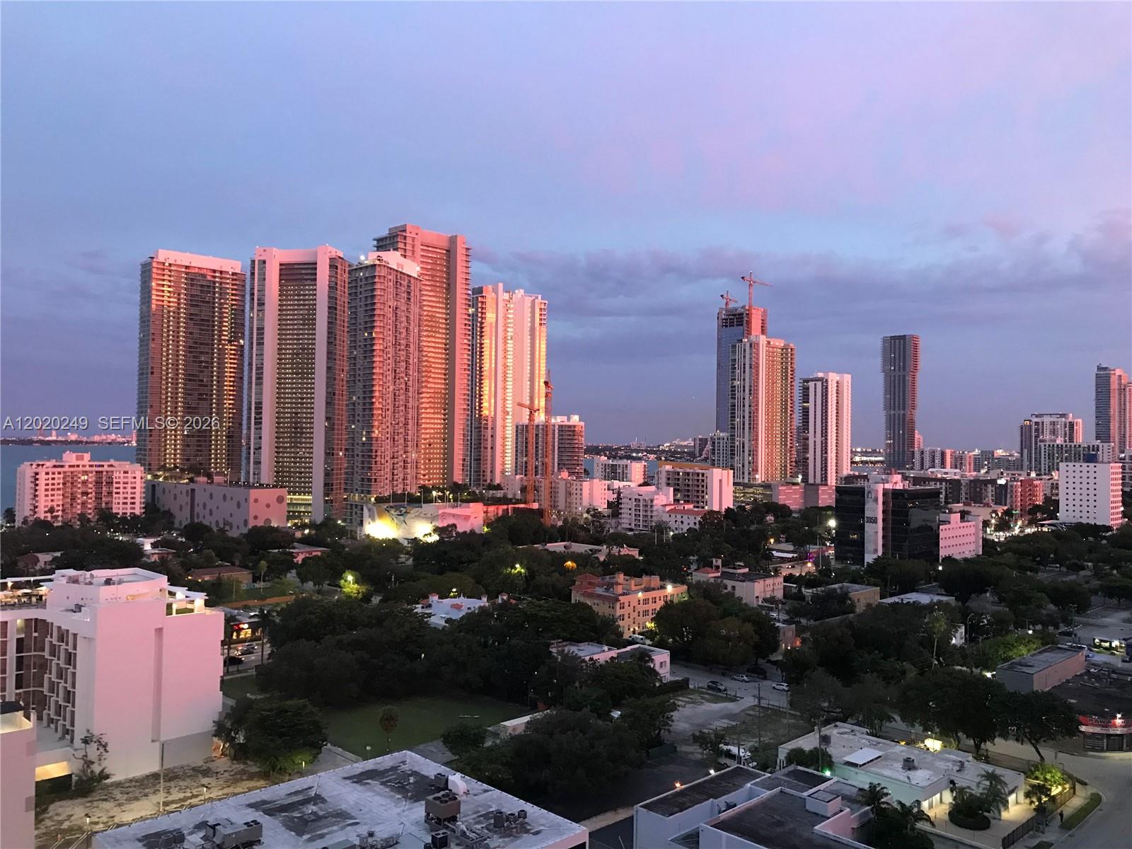 A kitchen features wood cabinets, stainless steel appliances, a black countertop, and a glass table — 3470 E Coast Ave # H1712, Miami FL 33137, MIAMI, FL
