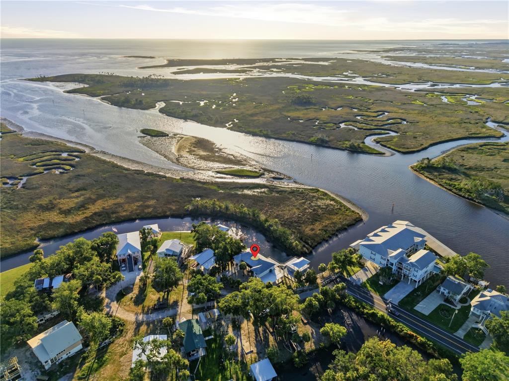 An aerial view shows a coastal property with a red location pin near a waterway — 38 SE 195TH STREET, SUWANNEE, FL