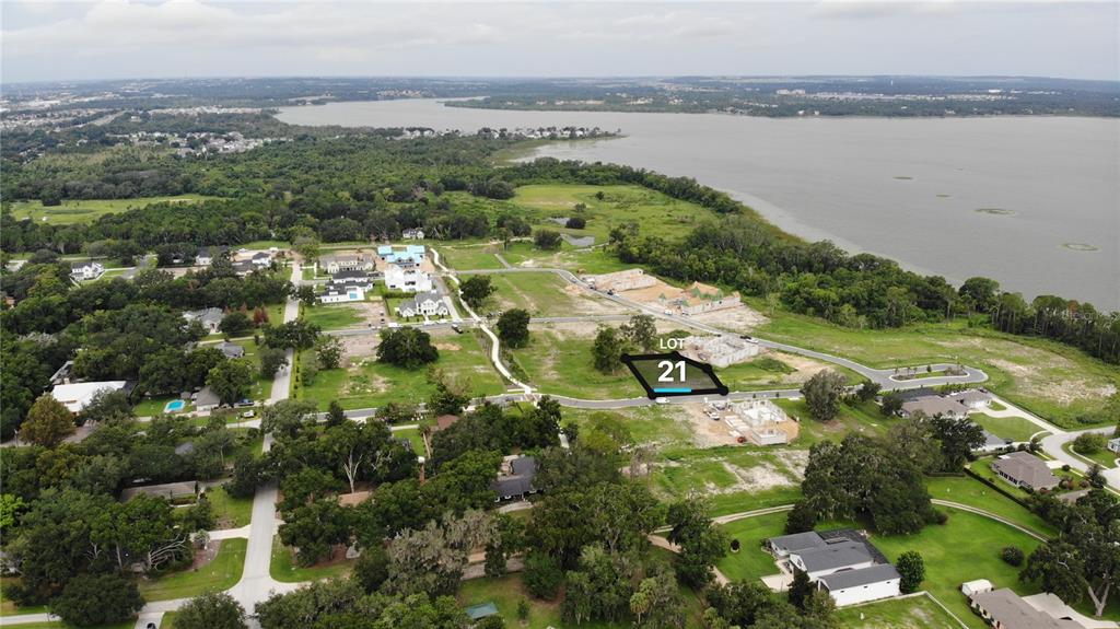 An aerial view shows a vacant residential lot marked 21 in a developing lakeside neighborhood — 523 WALKER STREET, OAKLAND, FL