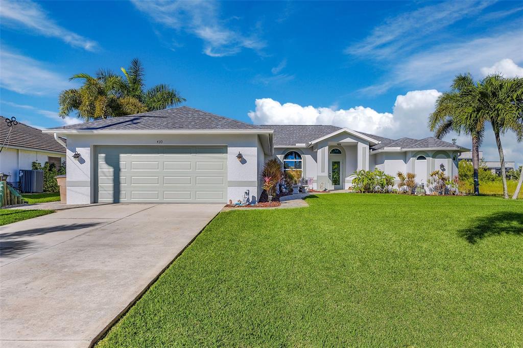 A single-story suburban house with a gray garage, light-colored stucco, and a manicured lawn — 430 NW 39TH AVENUE, CAPE CORAL, FL