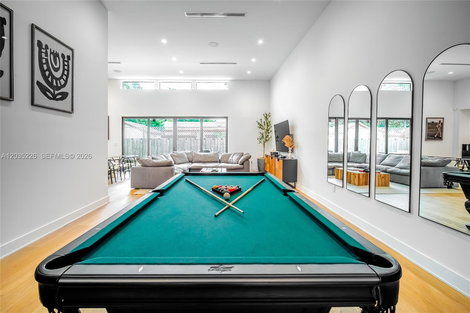 A game room features a pool table, three arched wall mirrors, and a living area — 243 NW 42nd St, Miami FL 33127, MIAMI, FL