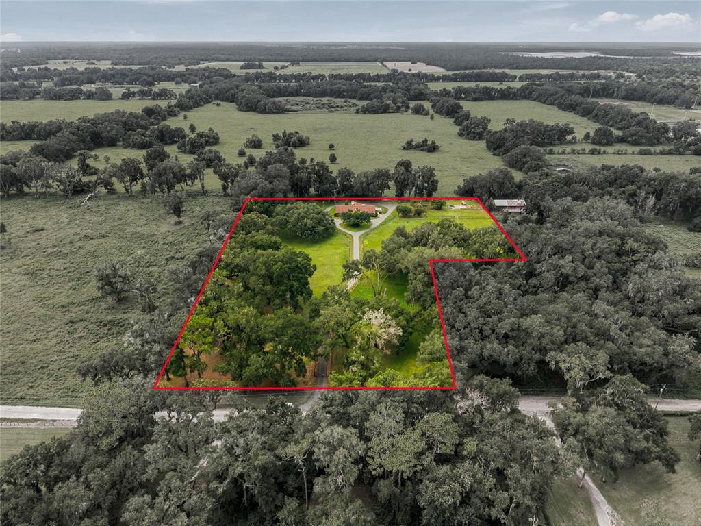 An aerial view shows a house with a driveway on a large, tree-filled rural lot — 690 SW 165TH STREET, OCALA, FL