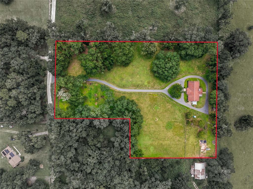 An aerial view shows a house with a circular driveway on a large, wooded lot — 690 SW 165TH STREET, OCALA, FL