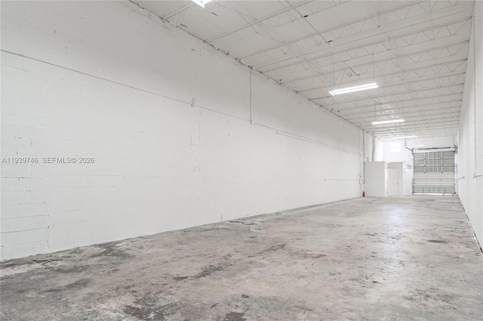 An empty industrial warehouse space features white painted block walls and a concrete floor — 453 W 28th St, Hialeah FL 33010, HIALEAH, FL