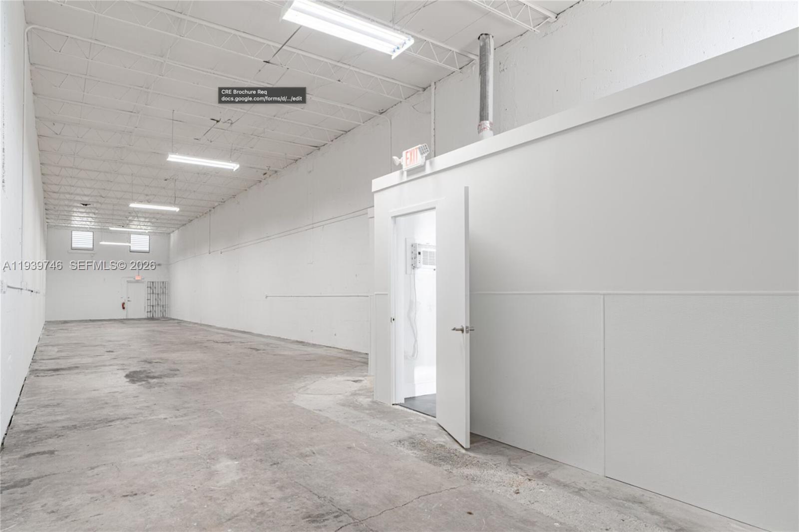 An empty industrial warehouse space features white walls, concrete floors, and an open office door — 453 W 28th St, Hialeah FL 33010, HIALEAH, FL