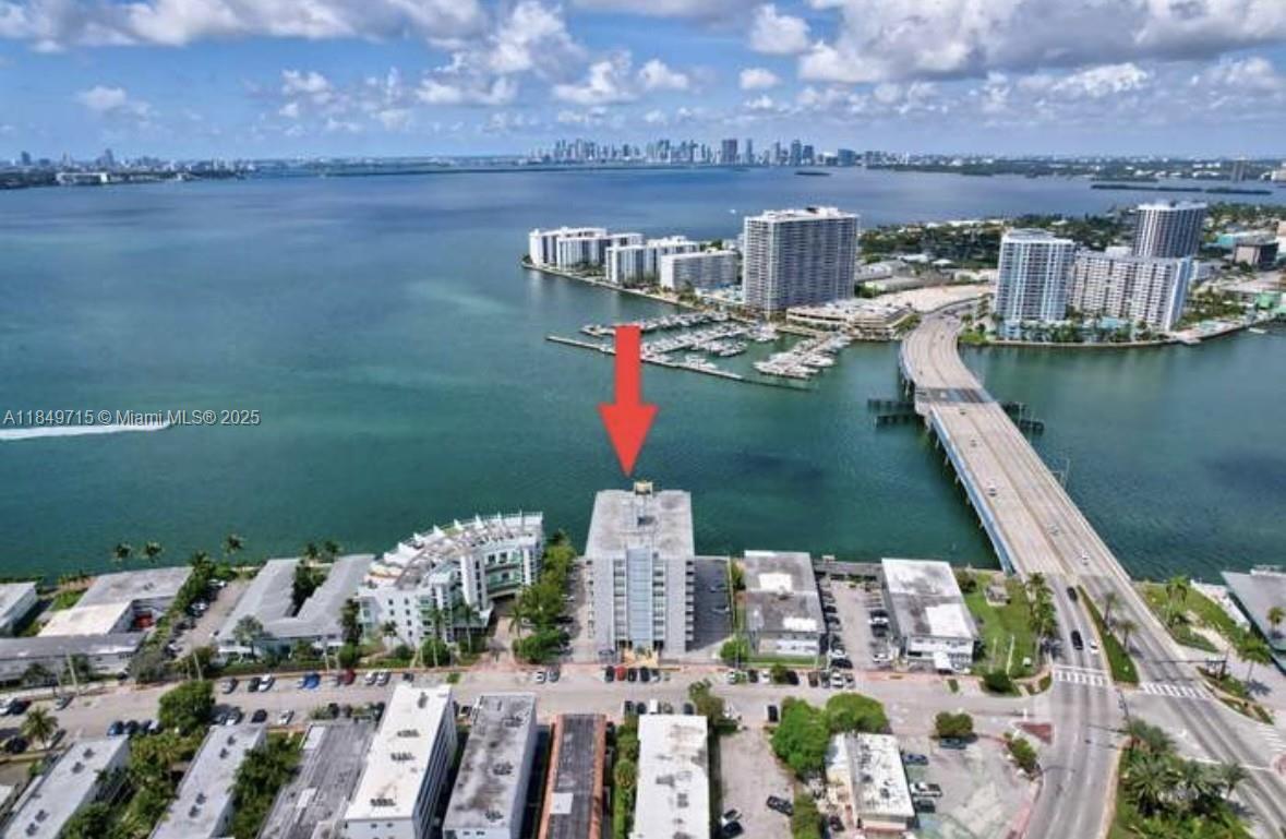 An aerial view shows a waterfront apartment building marked by a red arrow — 2016 Bay Dr # 202, Miami Beach FL 33141, MIAMI BEACH, FL