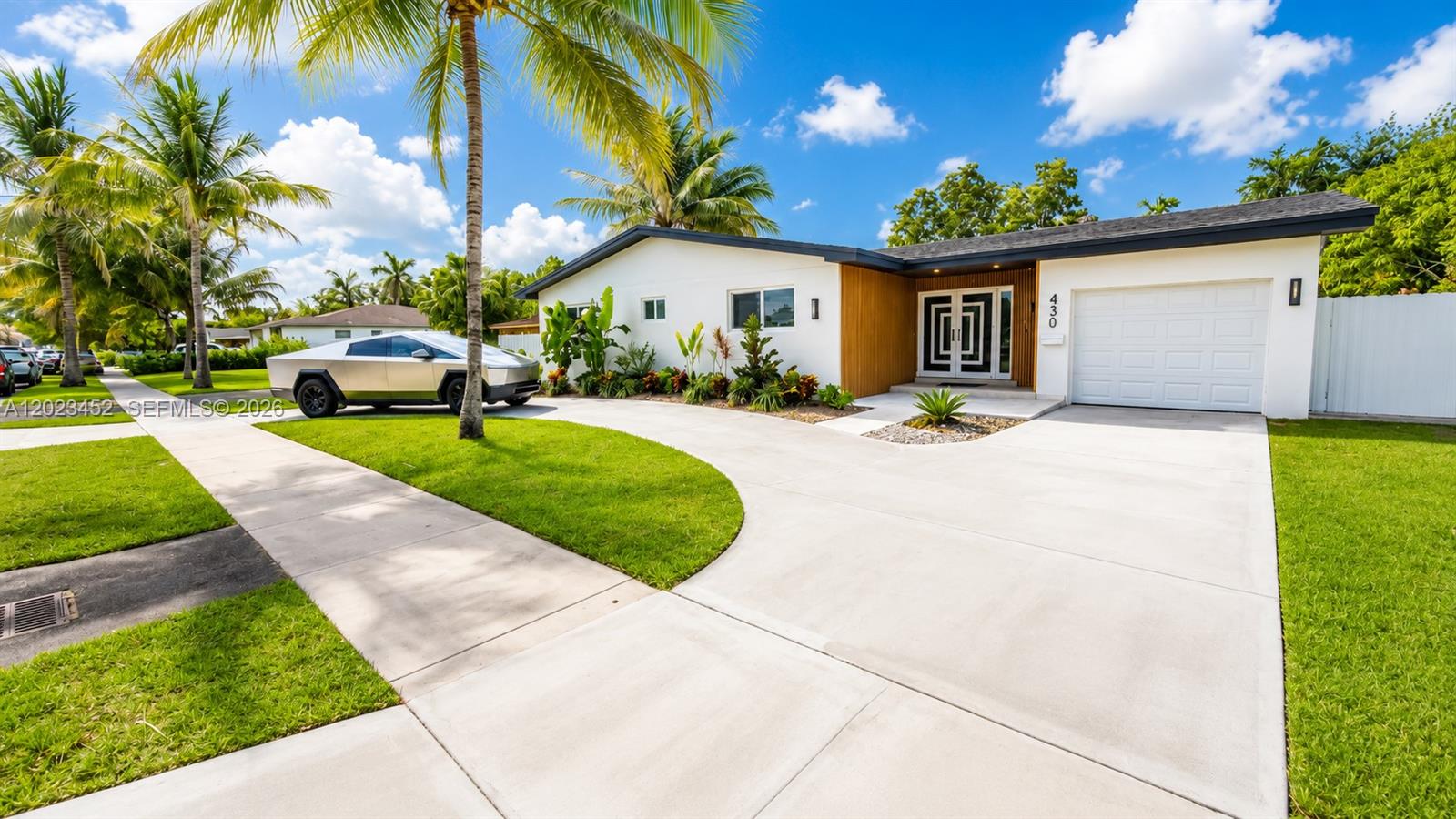 A single-story house with a white exterior, a garage, and a Cybertruck parked outside — 430 NE 145th St, Miami FL 33161, MIAMI, FL