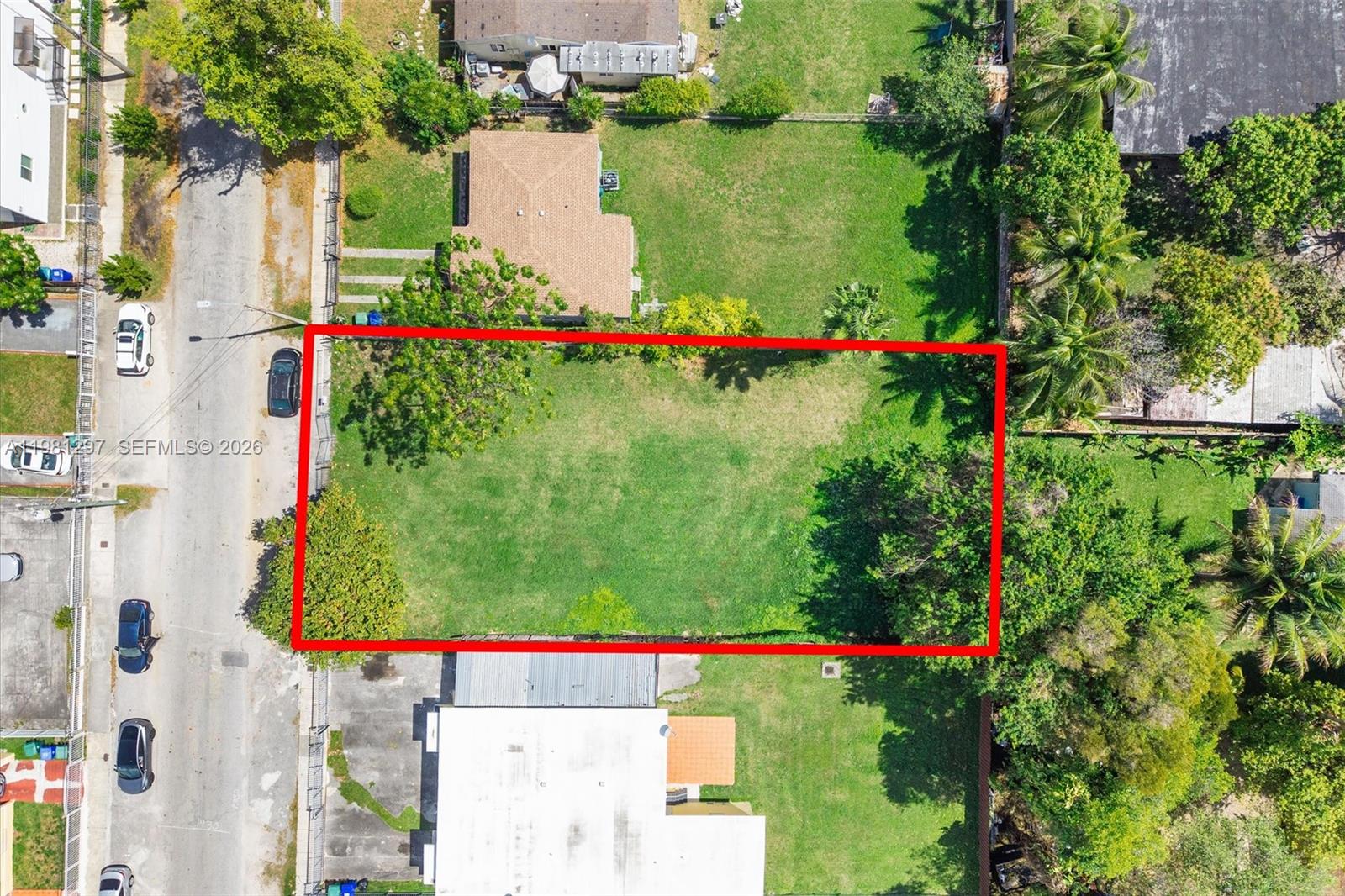 An aerial view shows a rectangular vacant grass lot outlined in red along a street — 1922 NW 33rd St, Miami FL 33142, MIAMI, FL
