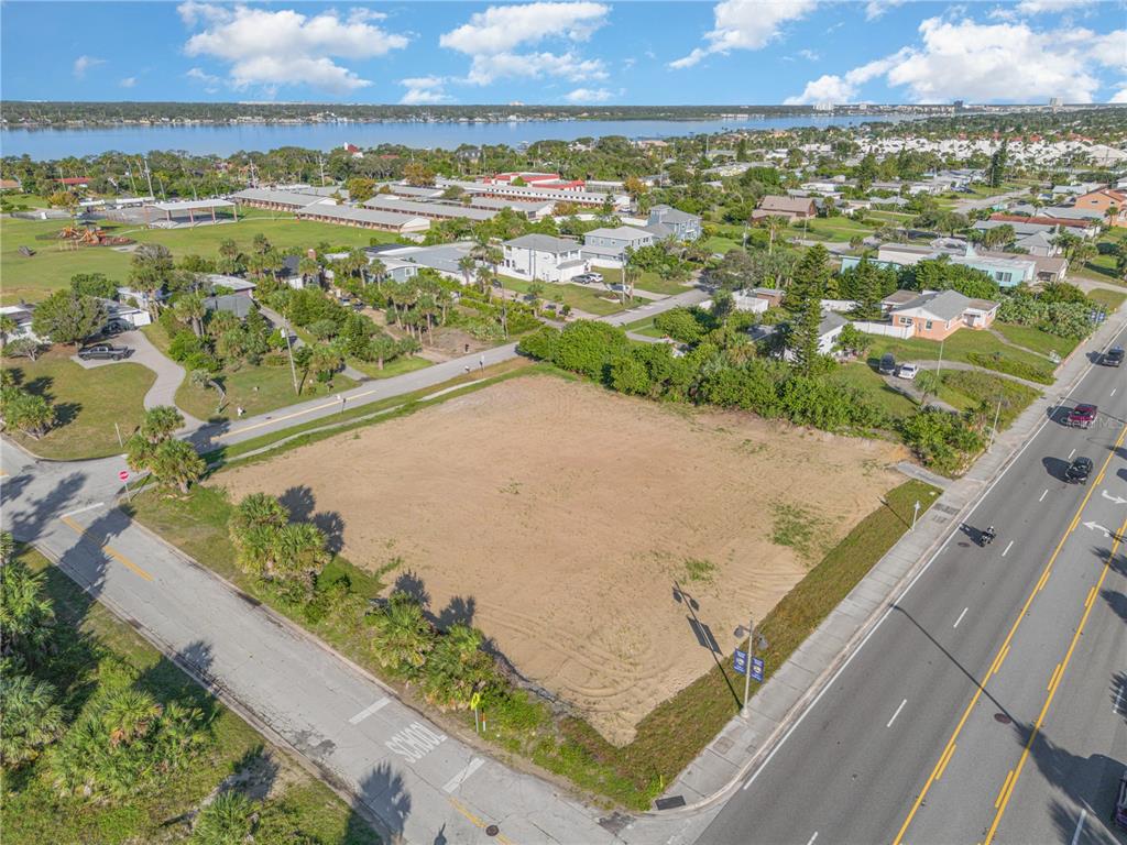 An aerial view shows a vacant, sandy corner lot bordered by two paved roads — 2752 S ATLANTIC AVENUE, DAYTONA BEACH, FL