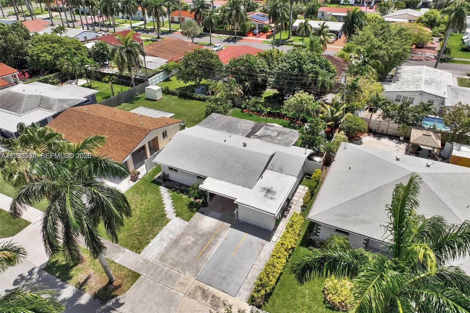 An aerial view shows a single-story house with a driveway, carport, and surrounding residential neighborhood — 814 NE 4th St, Hallandale Beach FL 33009, HALLANDALE BEACH, FL