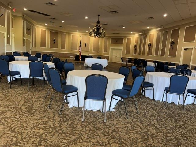 A large banquet hall features round tables with white tablecloths and blue chairs — 3912 ATRIUM DRIVE UNIT L7, ORLANDO, FL