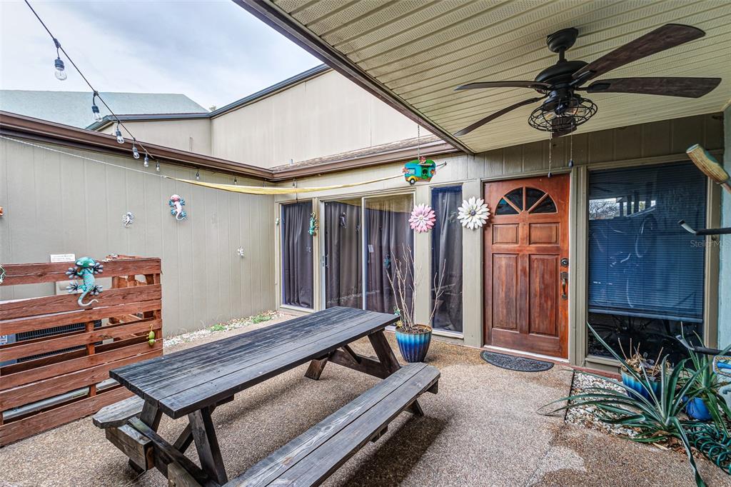 A wooden picnic table sits on a concrete patio outside a house with a wooden door — 2500 21ST STREET NW UNIT 23, WINTER HAVEN, FL