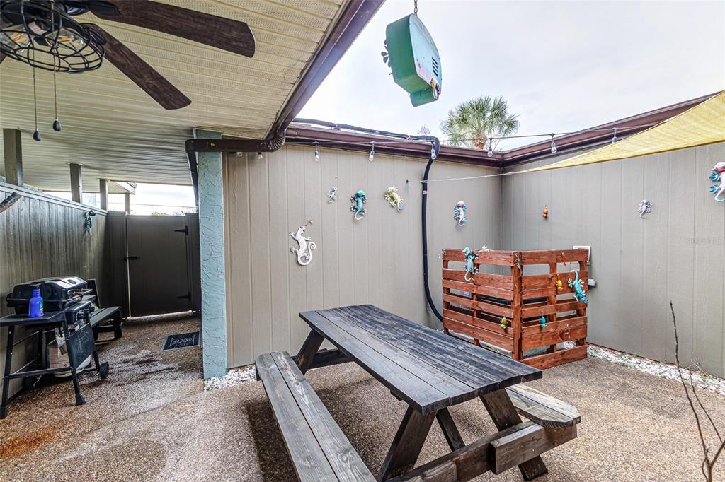 A patio area features a wooden picnic table, a grill, and decorative wall-mounted lizards — 2500 21ST STREET NW UNIT 23, WINTER HAVEN, FL