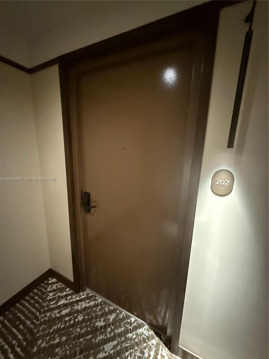 A brown door with a digital lock and a room number sign labeled 202 — 1611 SW 2nd Avenue # 202, Miami FL 33129, MIAMI, FL