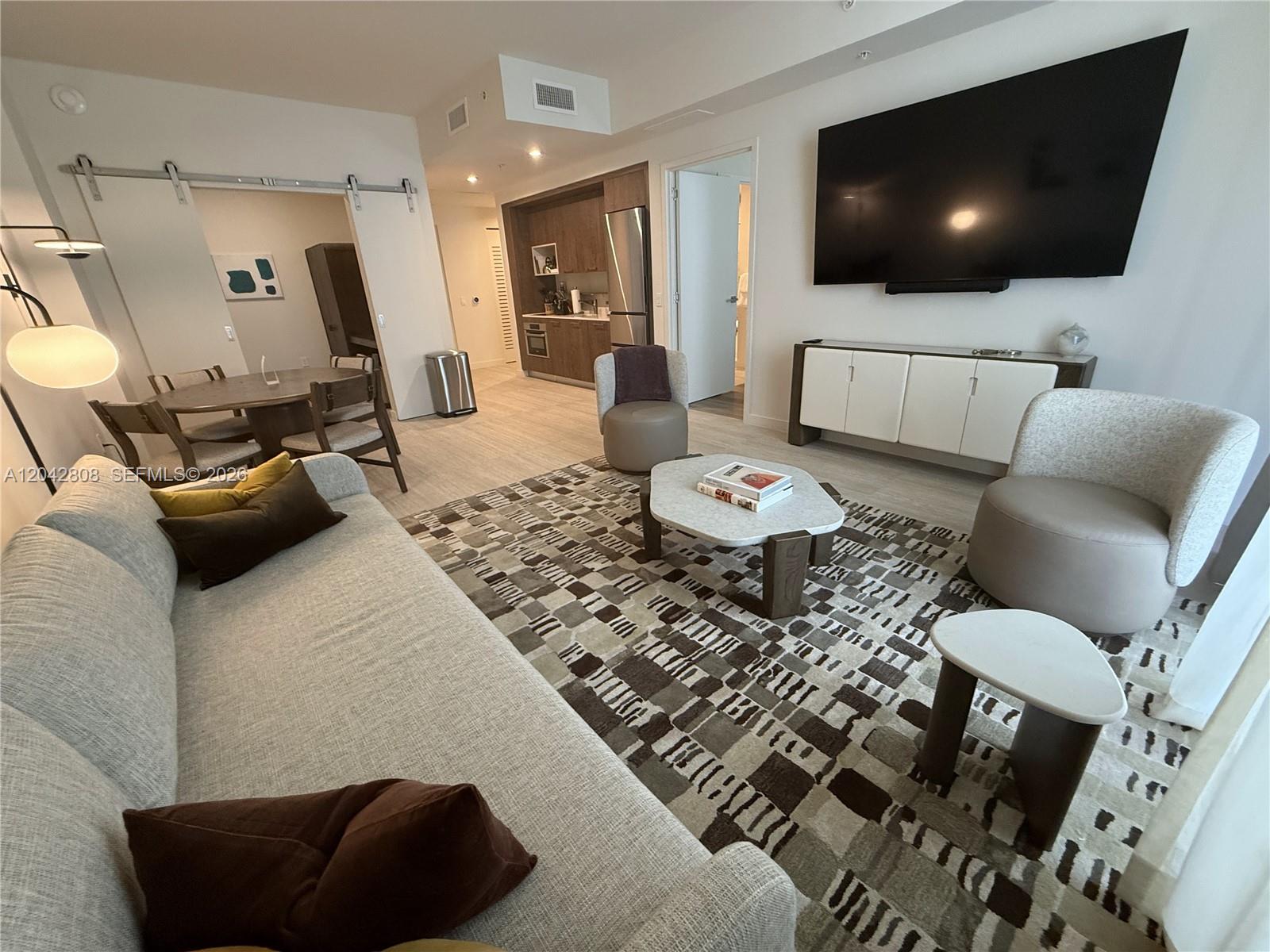 A living room features a sofa, patterned rug, coffee table, and an adjacent dining area — 1611 SW 2nd Avenue # 202, Miami FL 33129, MIAMI, FL
