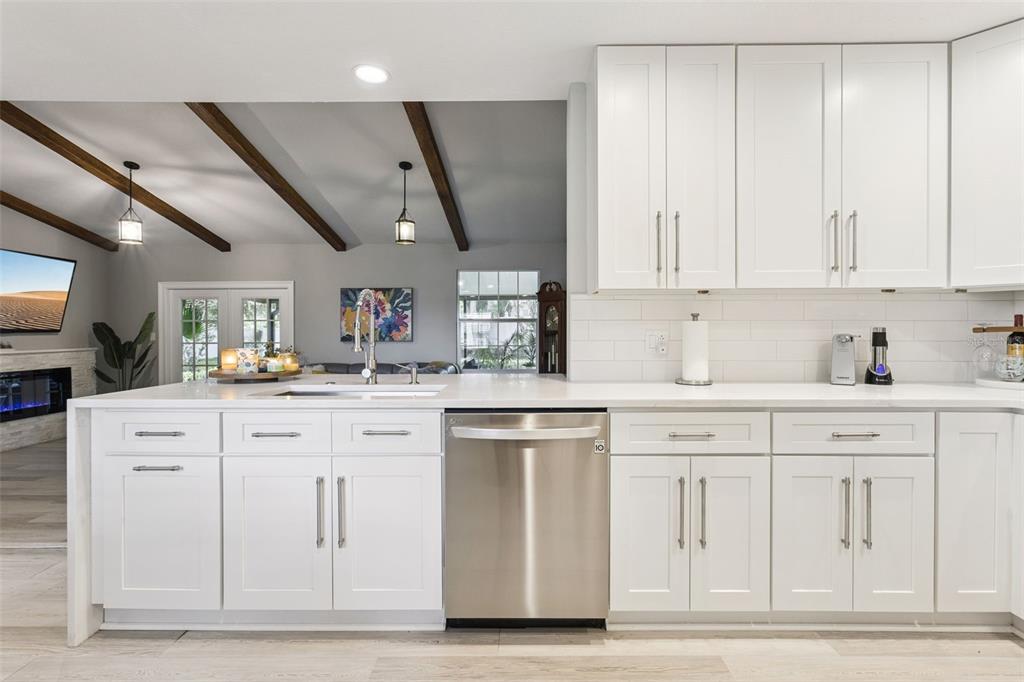 A modern kitchen with white cabinets, stainless steel appliances, and a large island — 1708 CREOLE COURT, ORLANDO, FL