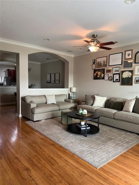 A living room features two beige sofas, a round coffee table, and a gallery wall — 10409 CRIMSON PARK LANE UNIT 105, TAMPA, FL