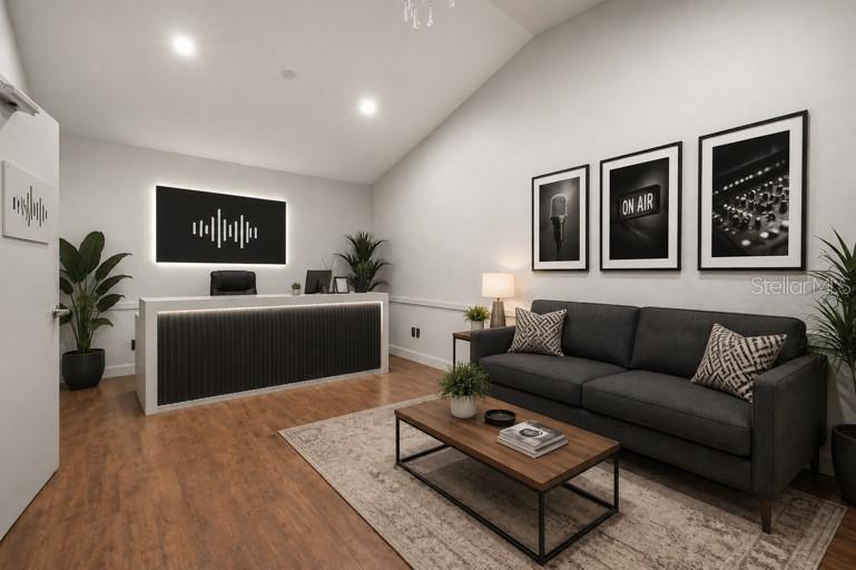 A modern office reception area features a dark desk, a gray sofa, and framed wall art — 2250 N VOLUSIA AVENUE, ORANGE CITY, FL