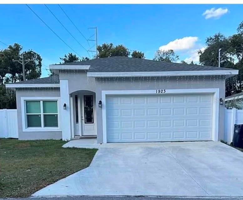 A single-story house with a gray exterior, a two-car garage, and a white front door — 1923 W SKAGWAY AVENUE, TAMPA, FL