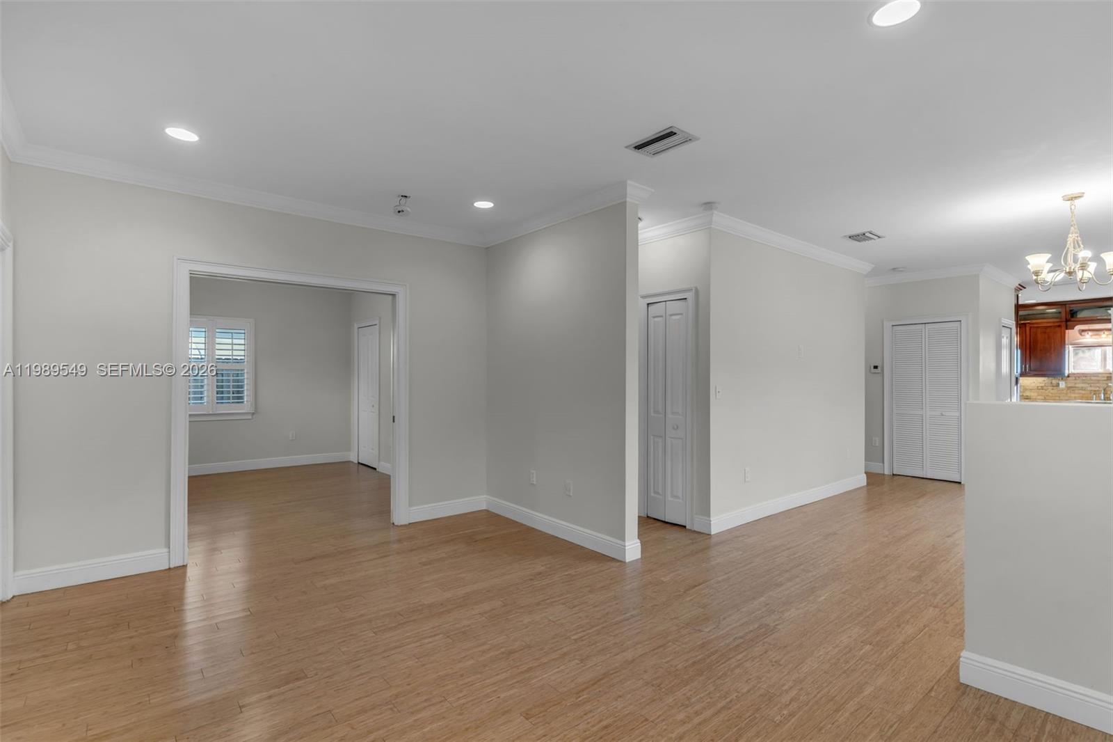 An interior view shows a living area with light-colored walls, wood flooring, and recessed lighting — 7048 SW 83rd Ct, Miami FL 33143, MIAMI, FL