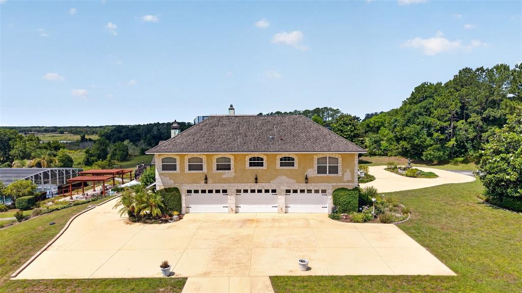 An aerial view shows a two-story house with a three-car garage and a large driveway — 17269 SE 260TH AVENUE ROAD, UMATILLA, FL