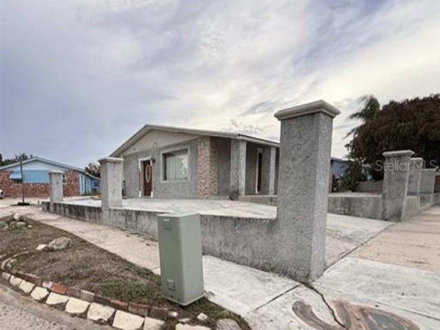 A single-story house with a stucco exterior and a concrete wall along the front yard — 1129 SW GOLDEN AVENUE, ARCADIA, FL